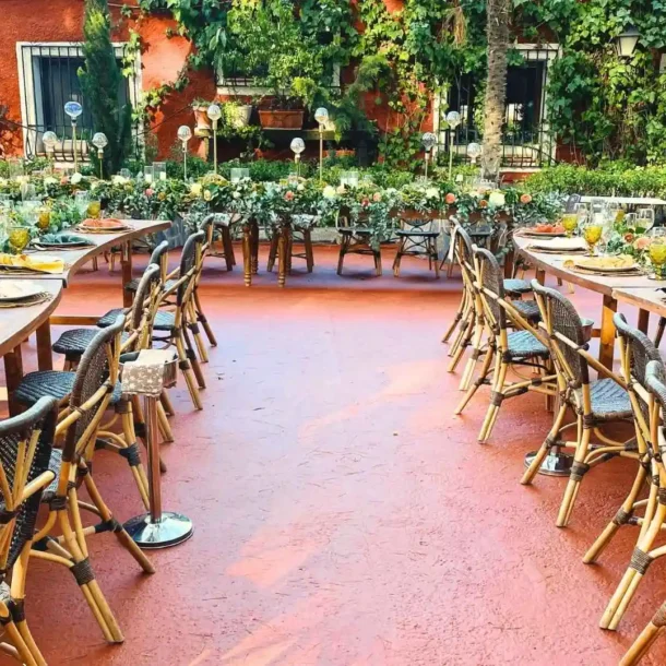 Asador La Casona, patio de la casona decorado con mesas, sillas y vajillas de calidad